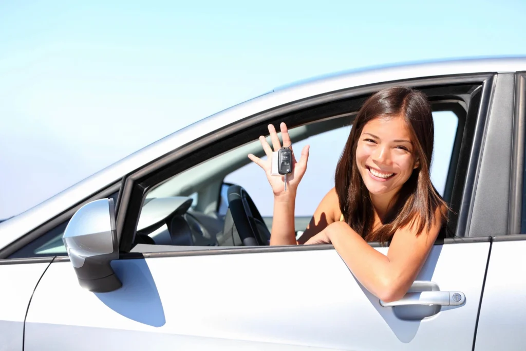 a happy lady obtaining an insurance for her new car